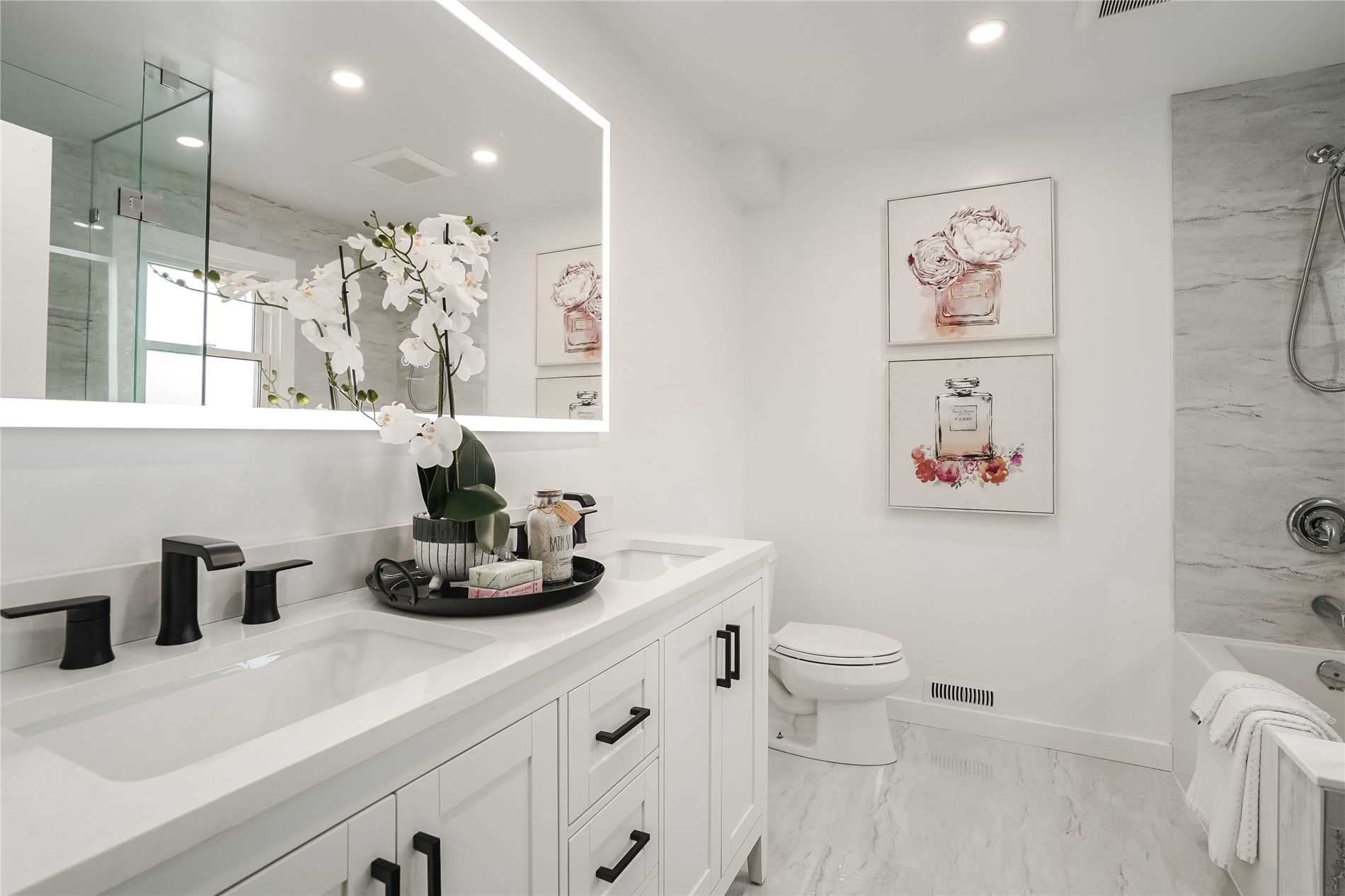 Renovated ensuite with illuminated mirror, double vanity and glass shower