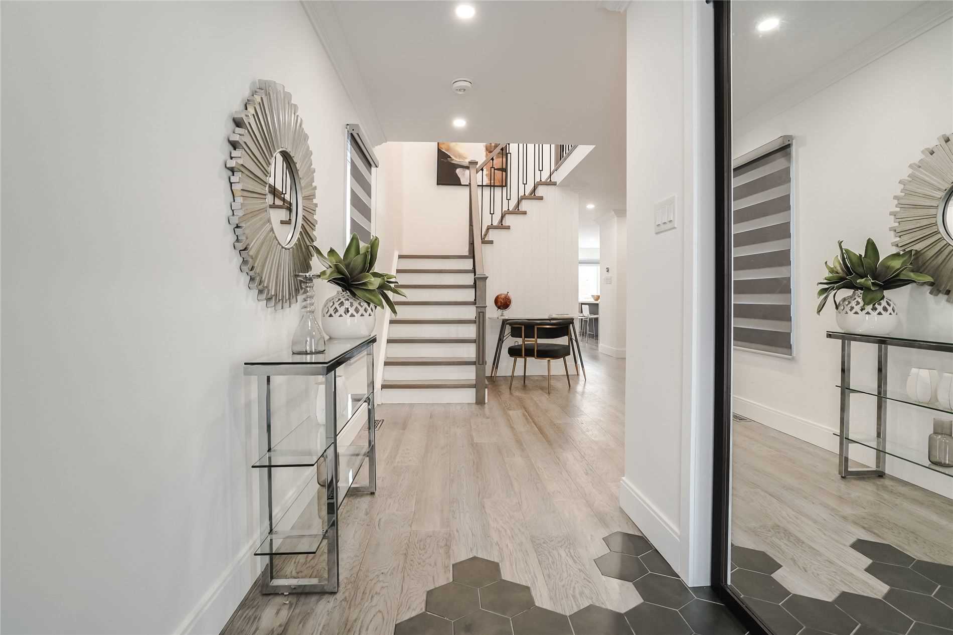 Renovated foyer with dark staircase, iron pickets and new flooring
